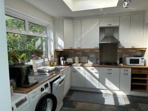 - une cuisine avec des placards blancs et une cuisinière dans l'établissement House for Rent in London, à Mill Hill