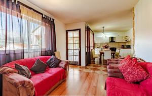 Una sala de estar con dos sofás rojos y una cocina. en Kiara, en Korčula