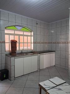 an empty kitchen with a sink and a window at Apartamento Confortável e Bem Localizado in Diamantina