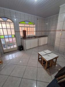 a kitchen with two windows and a table in it at Apartamento Confortável e Bem Localizado in Diamantina