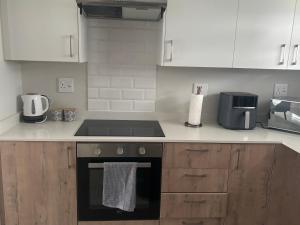a kitchen with white cabinets and a stove top oven at Mya Villa 2 in Fourways