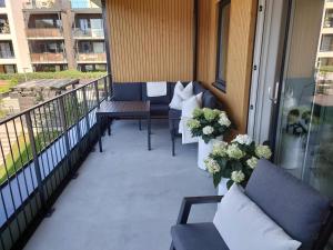 a balcony with couches and flowers on a building at Stilren leilighet midt på Lade in Trondheim