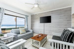 a living room with a couch and a tv at Eden Dunes 68 in Shelly Beach