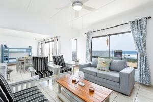 a living room with a couch and a table at Eden Dunes 68 in Shelly Beach