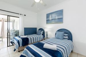 a bedroom with two beds with blue and white stripes at Eden Dunes 68 in Shelly Beach +26 photos
