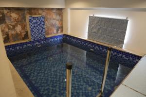 a swimming pool with blue tiles in a room at Hotel HS Inn Swiming Pool Room in Jaipur