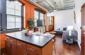 a kitchen with a large island in a living room at NY Style Loft with King Bed in Rochester