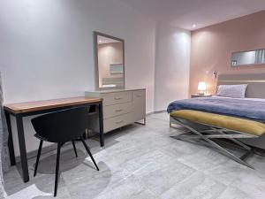 1 dormitorio con 1 cama, escritorio, 1 cama y 1 falda en Luxury flat Dakar, en Point E