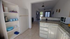 a kitchen with white cabinets and a white refrigerator at Los Aromos Sinsacate in Sinsacate