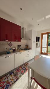 a kitchen with white cabinets and a table in it at Grazioso bilocale a Legnano. in Legnano