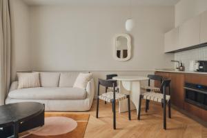 a living room with a couch and a table and chairs at Nestay Sentier in Paris