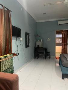 una sala de estar con un sofá y una mesa en Hj Hassan Guest House- Studio Unit, en Kuala Terengganu