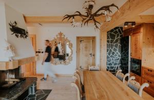 a woman walking through a room with a fireplace at Skyview Apartment in Kościelisko