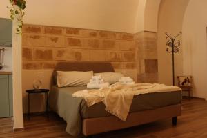 a bedroom with a bed with towels on it at Vita Lenta Apulian rooms in Trani +36 photos