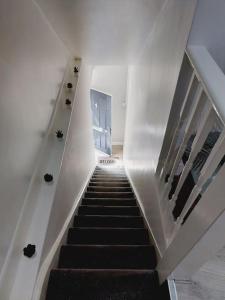 a staircase in a building with a black stair case at Seaside Apartment in Moreton +16 photos