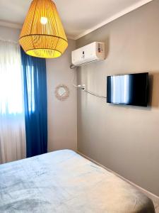 een kamer met een bed en een lamp die aan de muur hangt bij Departamento Temporal Constituyentes in Santa Fe