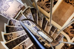a spiral staircase with blue and white tiles at Le Mireille in Paris