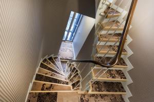 a spiral staircase with a mirror on the wall at Le Mireille in Paris