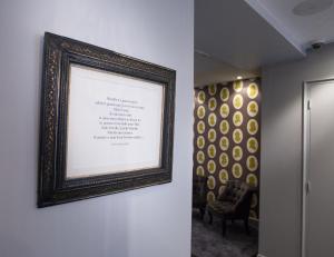 a picture frame hanging on a wall with a chair at Le Mireille in Paris