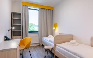 a room with two beds and a desk and a window at Hotel Active Stadium in Lovosice +33 photos
