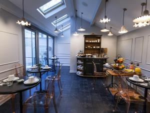 a dining room with tables and chairs and windows at Le Mireille in Paris