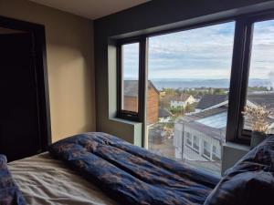 a bedroom with a bed and a large window at New and trendy home with fjord view in Ranheim