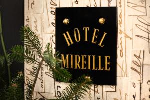 a sign that reads hotel miracle next to a christmas tree at Le Mireille in Paris