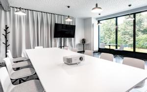 a white conference room with a white table and chairs at Hotel Active Stadium in Lovosice
