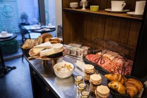 a breakfast buffet with bread and pastries on a counter at Le Mireille in Paris