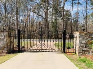 a black gate with a sidewalk in front of a park at Chateau d' Amour - Where Love & Luxury Meet in Wake Forest