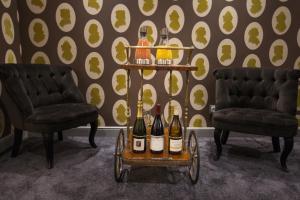 a cart filled with bottles of wine sitting between two chairs at Le Mireille in Paris