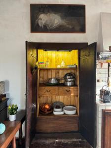 an open cabinet in a kitchen with pots and pans at la Contessa in Mazzano Romano +26 photos