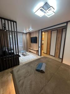 a bedroom with a bed and a flat screen tv at Лободы 33 in Karagandy