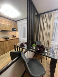a dining room with a glass table and chairs at Лободы 33 in Karagandy