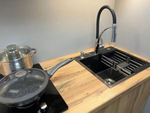 a frying pan sitting on a counter next to a sink at Лободы 33 in Karagandy +4 photos