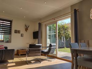 a living room with a table and chairs and a sliding glass door at HOMARUS Bed by the Sea in Westkapelle