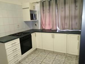 a kitchen with white cabinets and a black stove top oven at Corona Del Mar 7 in Margate