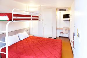 una camera con letto a castello e copriletto rosso di Premiere Classe Saint Nazaire - Trignac a Trignac