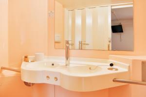 un lavandino bianco in un bagno con uno specchio di Premiere Classe Saint Nazaire - Trignac a Trignac
