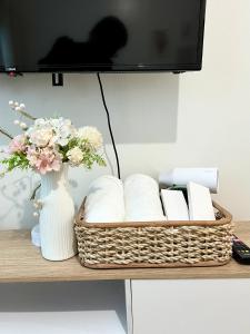 a shelf with a vase of flowers and a television at Casa Luna Unit 1 in Manila