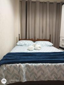 a bedroom with a bed with two towels on it at Um apartamento aconchegante in São Lourenço