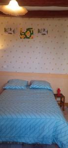 a bedroom with a blue bed with posters on the wall at La maison paisible au village in Channay-sur-Lathan