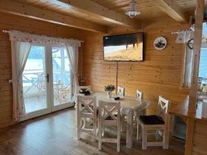 a dining room with a table and a television on a wall at Arctic House in Dolný Kubín +28 photos