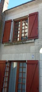 a building with red doors and windows on it at La maison paisible au village in Channay-sur-Lathan