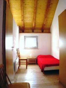 マッジャにあるCasa Elinの赤いベッドと窓が備わる客室です。