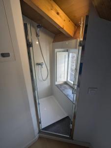 eine ebenerdige Dusche in einem Raum mit Fenster in der Unterkunft Casa Muralla in Ribadeo