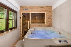 una grande vasca blu in una stanza con finestra di Gorska bajka - Jela, kuća za odmor i wellness a Stara Sušica