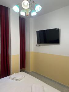 SALENTINI APPARTAMENTo في روما: غرفة نوم مع تلفزيون بشاشة مسطحة على جدار