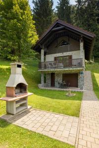 una casa con un forno per pizza davanti di Gorska bajka - Jela, kuća za odmor i wellness a Stara Sušica