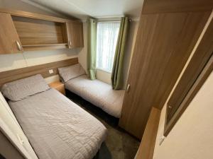 a small room with a bed and a window at Lake District Stunning Lodge in Plumbland